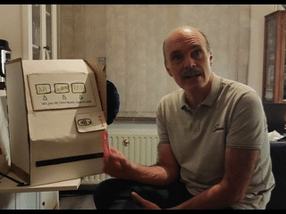 Gif van een figuur die een pasje vast houdt voor het kartonnen prototype en praat 